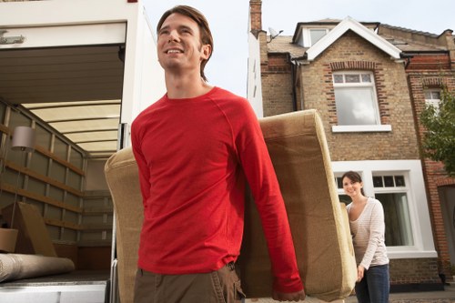 Piano movers protecting floors and stairways during a Chelsea relocation