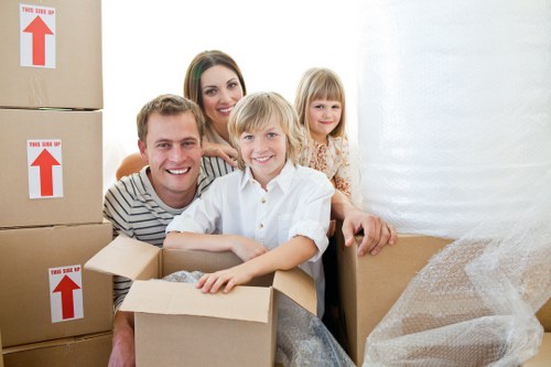 Movers carrying furniture through a Chelsea building with narrow access